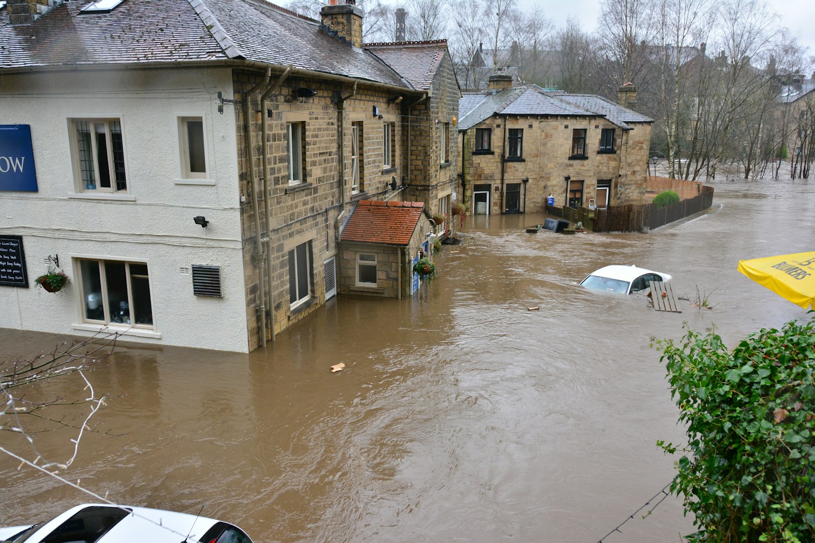 brown and white concrete house who needs flood insurance beside river during daytime